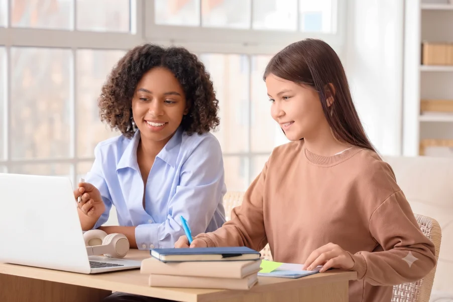 A tutor and student working together at a laptop during an online tutoring session